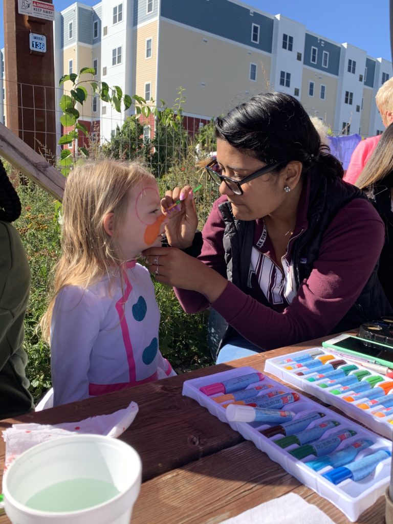 Senior Yadira Duarte focusing on her masterpiece of a butterfly being painted on the little girls face. Photo taken by Sabrina Monteiro.