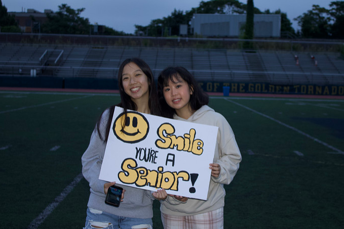 Class of 2025 officers Jaslie Fang and Jessica Li posing with a homemade sign. THOMAS TIERNEY